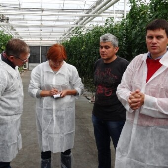 Ubrani na biało przedstawiciele firmy Azelis - od lewej Niels Holmenlund, Barbara Głaczkowska oraz Jacek Ceglarski - w towarzystwie gospodarza drugiego z odwiedzonych gospodarstw, Marka Wojtczaka