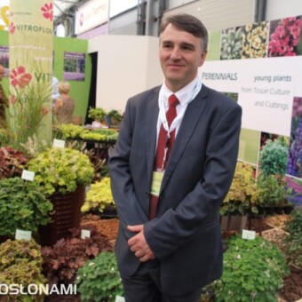 Tomasz Michalik na tle stoiska, na którym prezentowano byliny (fot. A. Cecot)